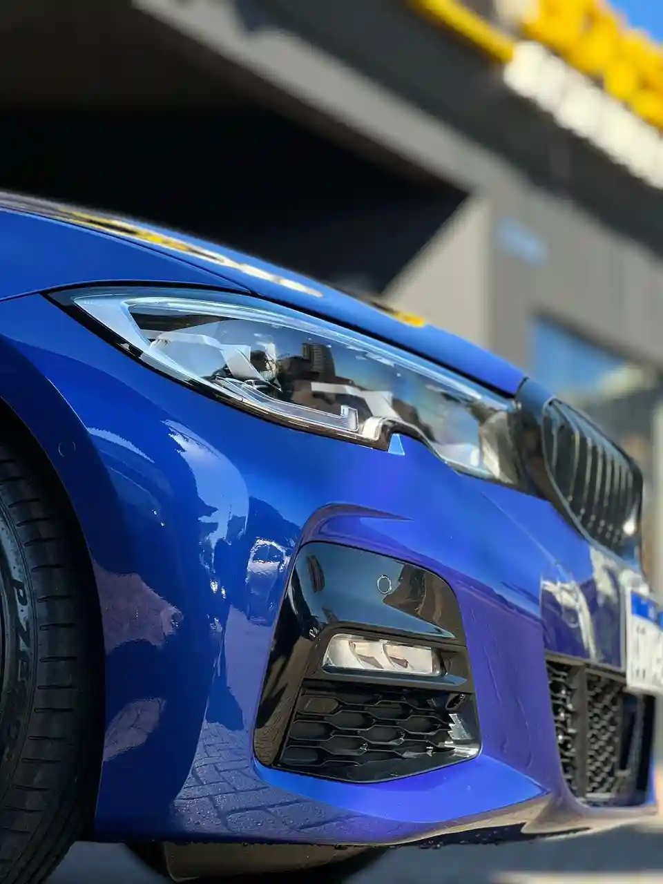 BMW azul de frente com pintura brilhando